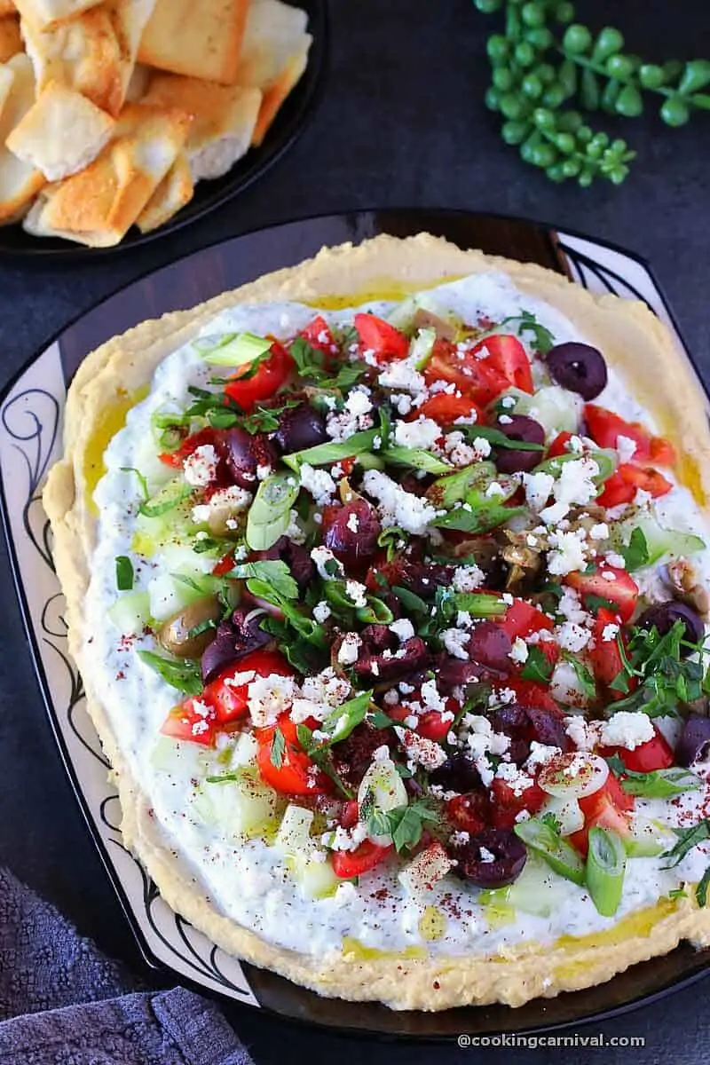 7 layer greek dip in a black tray