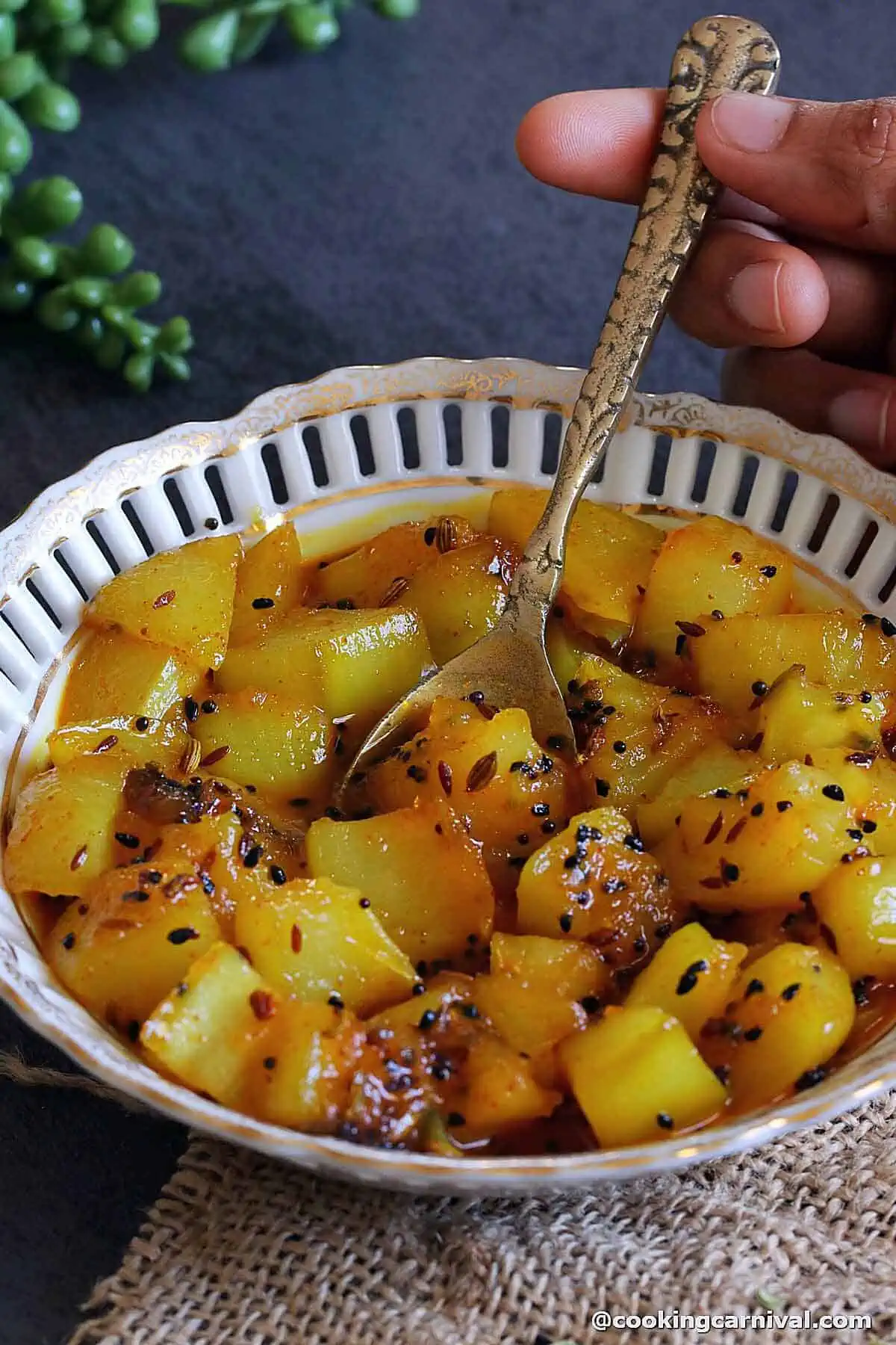 taking aam ki launji with spoon from the bowl.