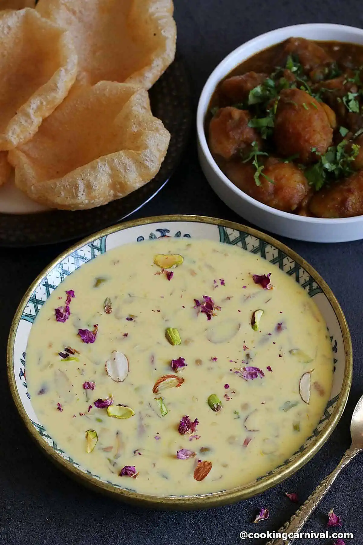 Basundi, a traditional Indian dessert, in a bowl served with poori and potato curry.