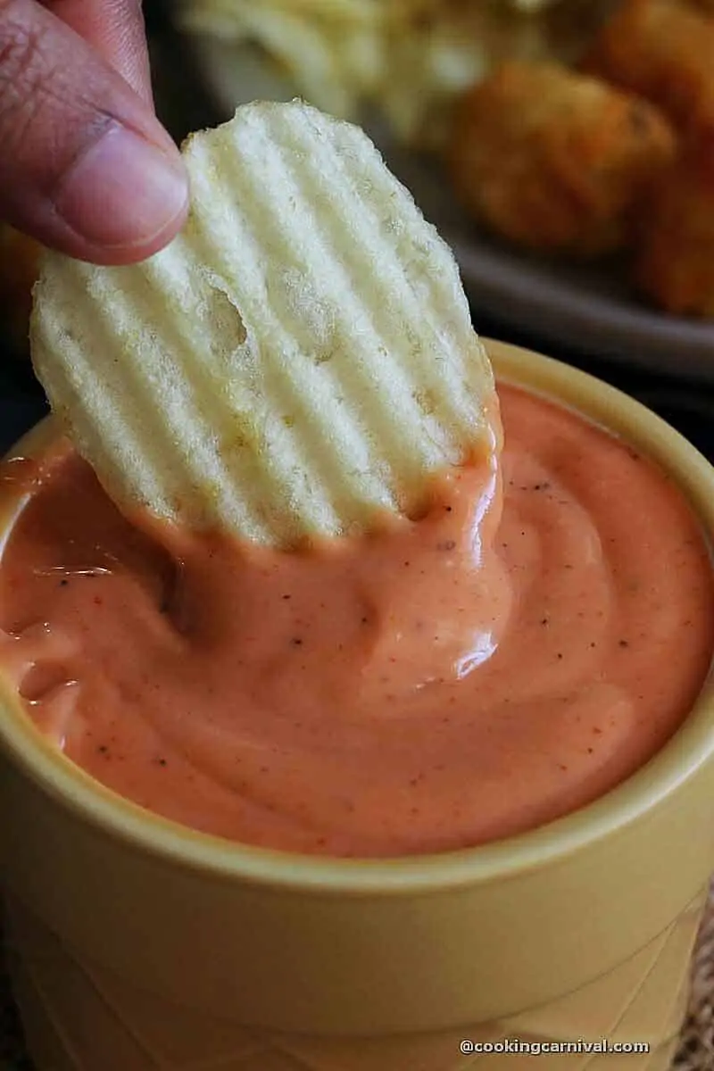 Dipping potato chips in boom boom sauce