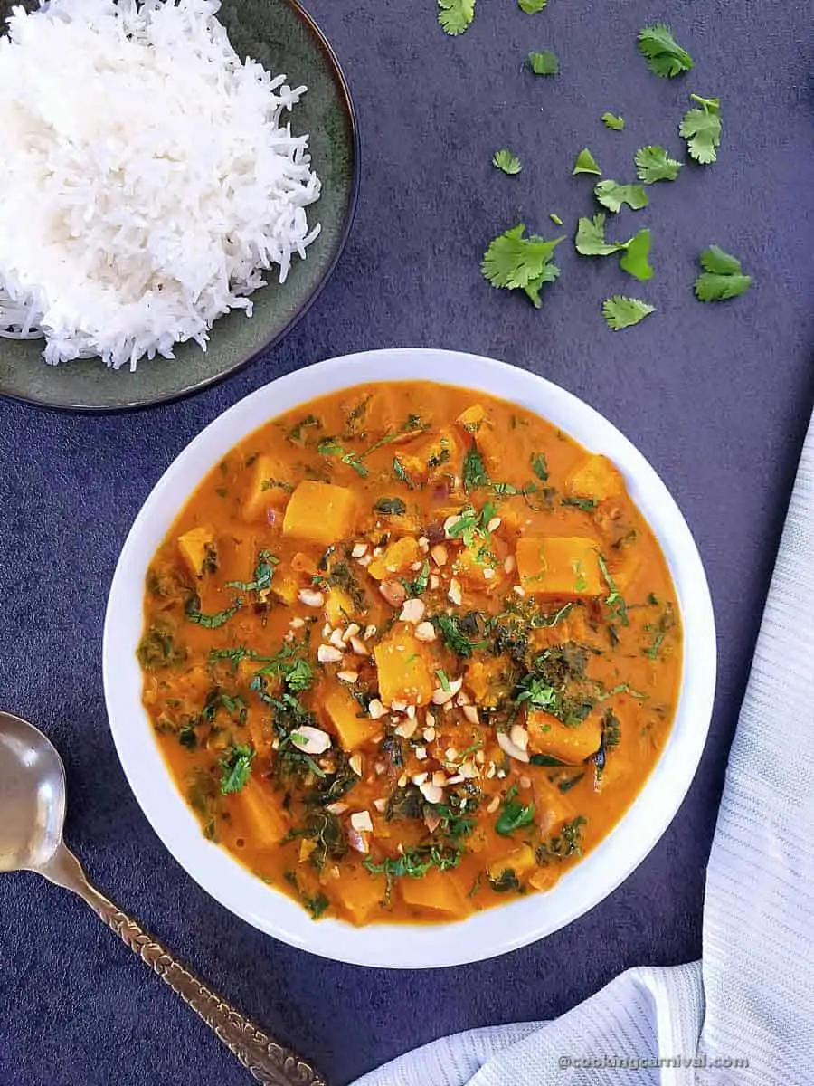 Thai butternut squash curry in a white bowl, rice on a side.