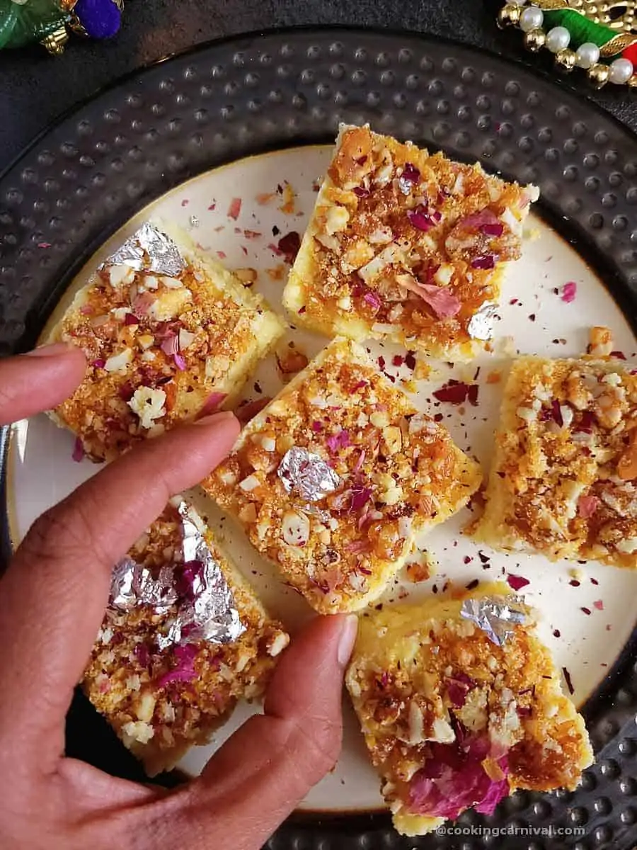 taking butterscotch burfi from a plate