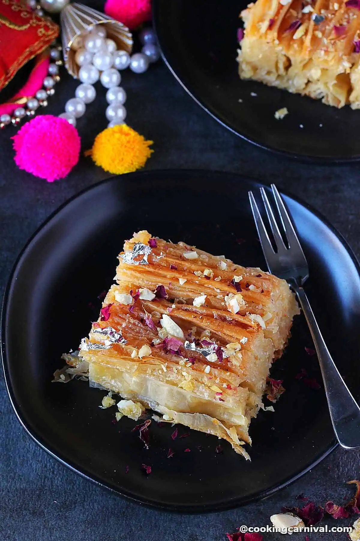 Phyllo crinkle cake on a black plate.