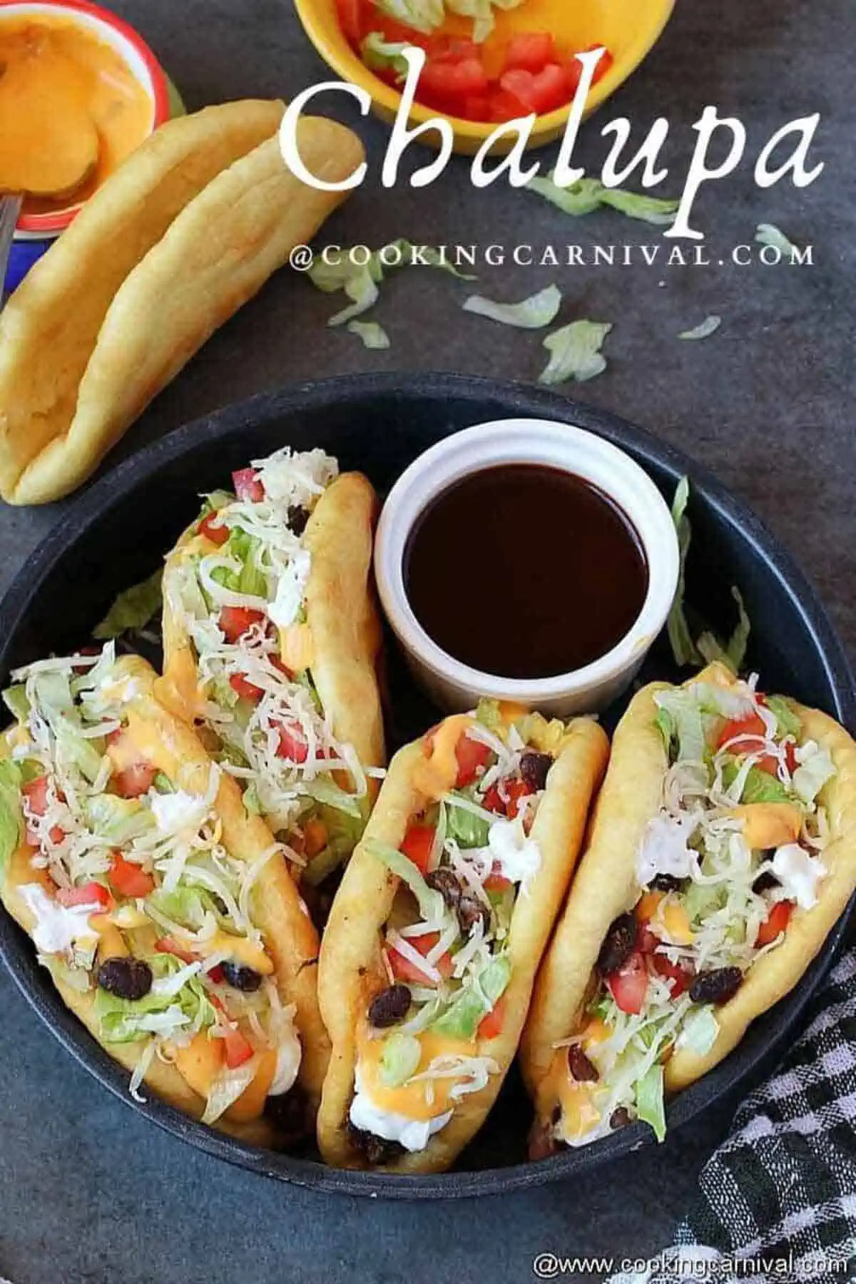 four homemade chalupas in a baking pan with hot sauce.