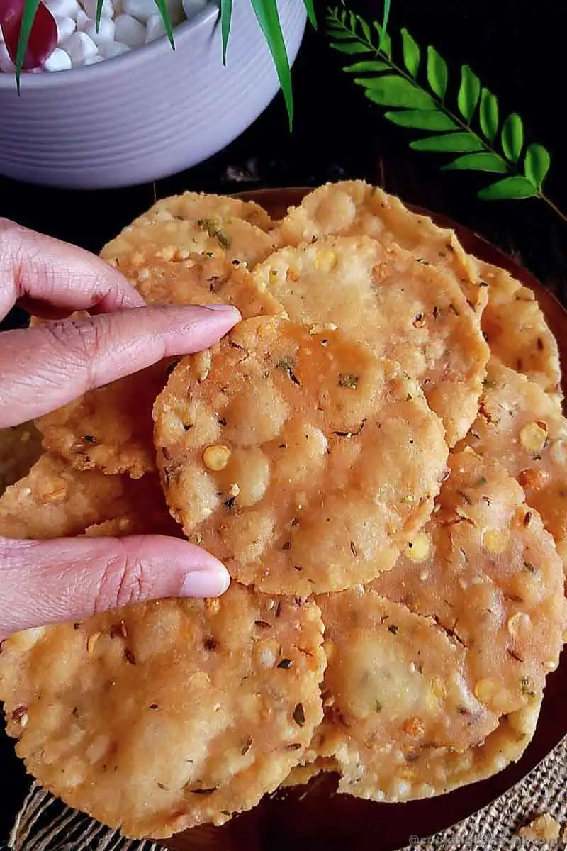 Picking up South Indian Snack Chekkalu from the plate.