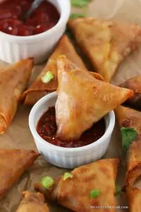 dipping noodle samosa in schezwan sauce