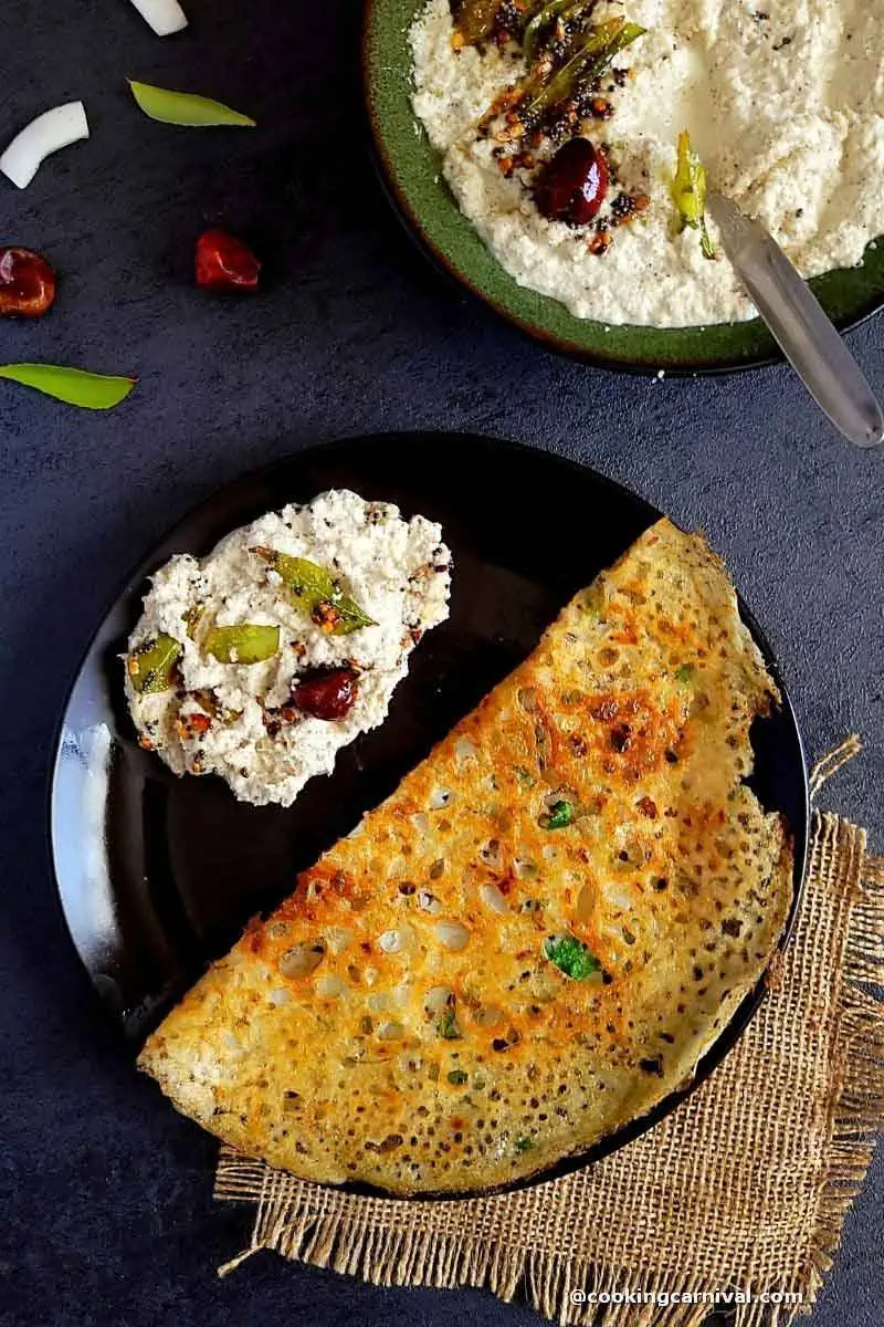 rava dosa with coconut chutney in a black plate