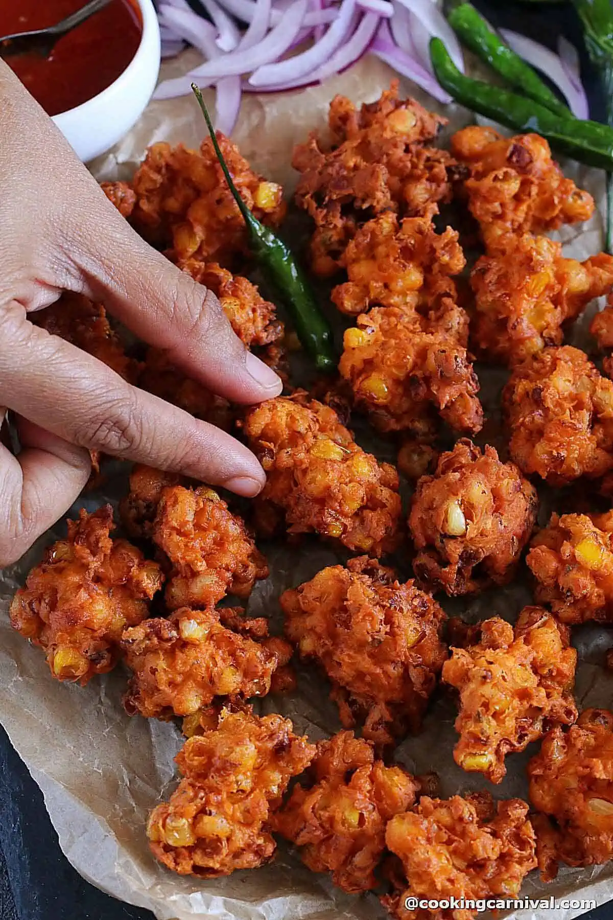 picking up corn bhajias with hand.