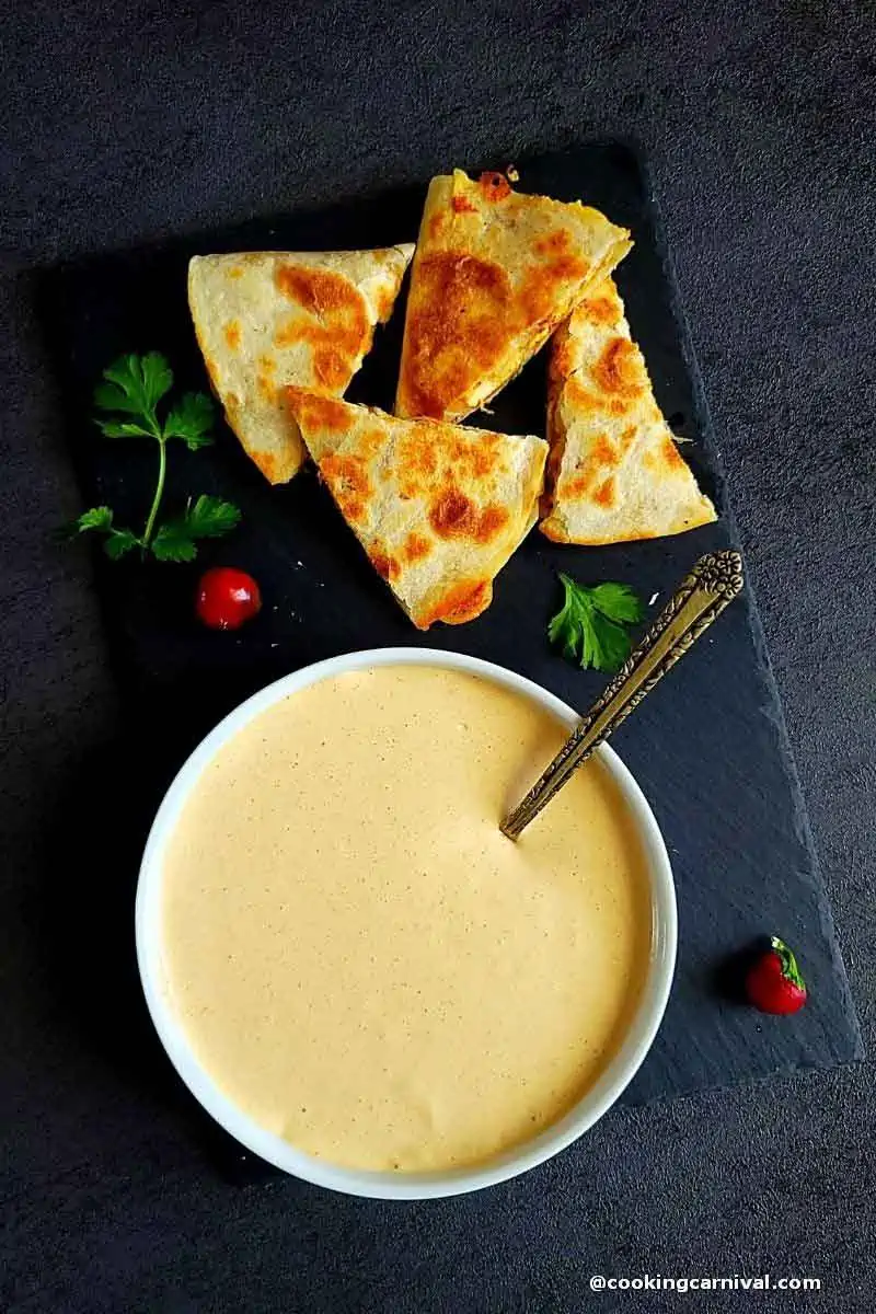 creamy jalapeno sauce in a white bowl, quesadilla on the side