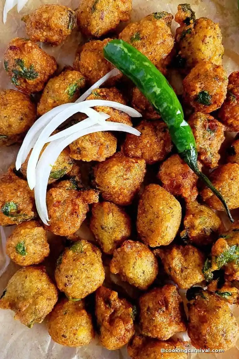 Close up shot of moong dal vada, onion and green chili on top