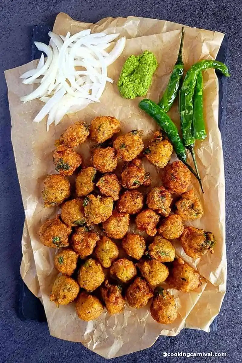 Gujarati Dal vada on cheese board with fried green chilies, onion and green chutney.