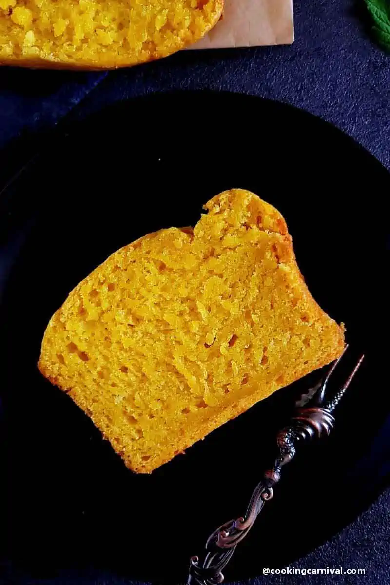 Slice of mango cake on a black plate with fork