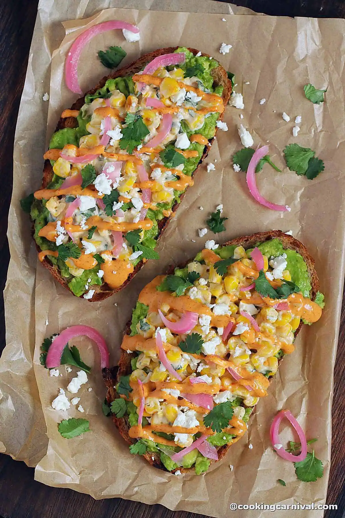 two elote avocado toast on brown paper.