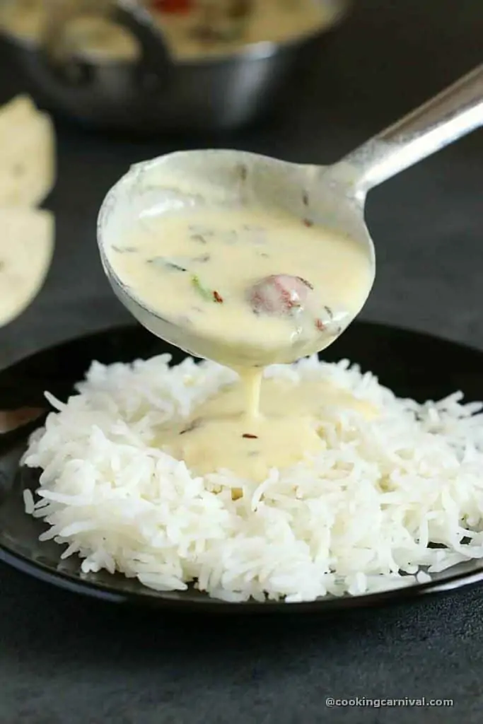 Pouring gujarati kadhi over basmati rice