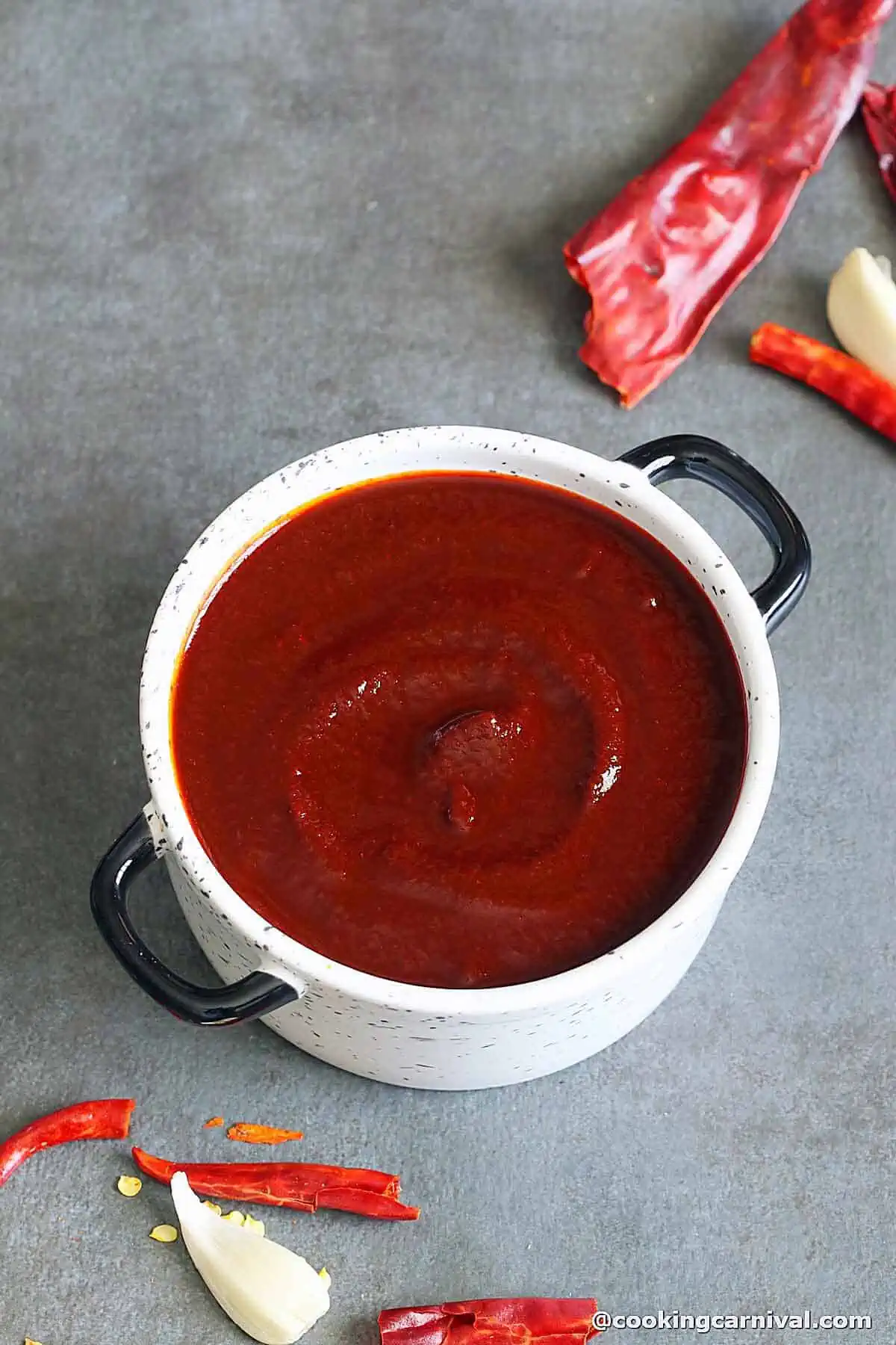 homemade enchilada sauce made with chile, served in a white bowl.