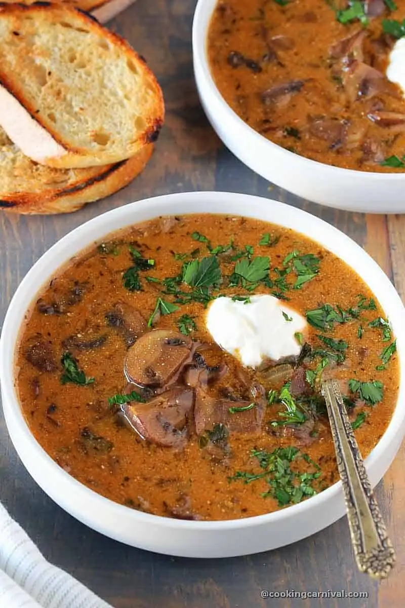 Hungarian Mushroom Soup served in white bowl with crusty bread