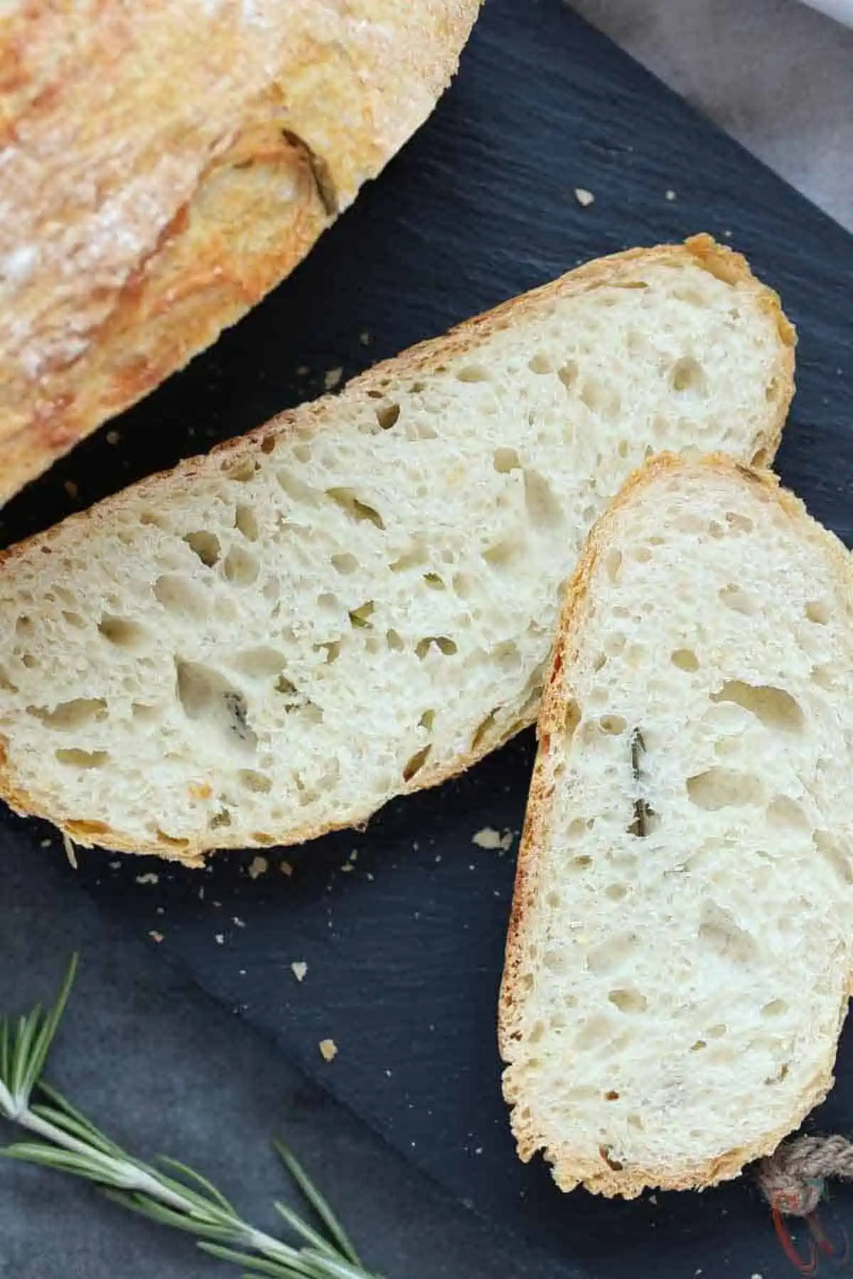 slices of no knead bread on a cheese board.