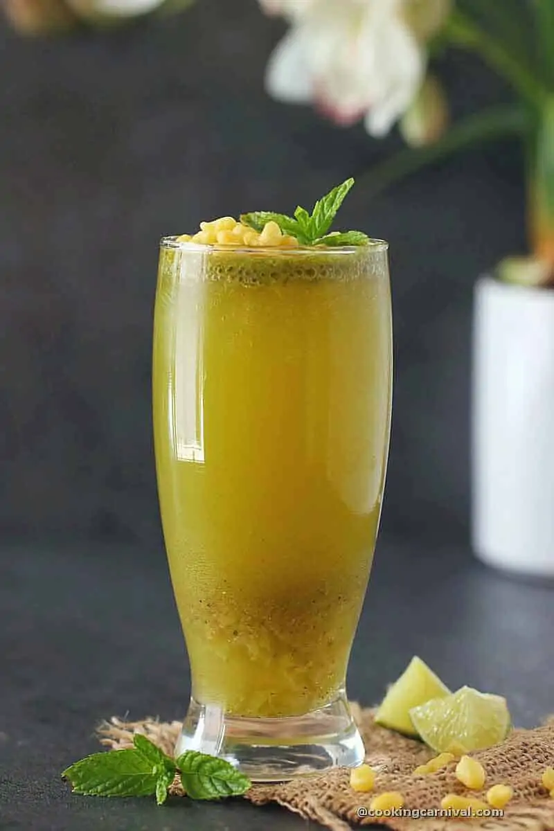 Pineapple Jaljeera in a glass, garnished with boondi and mint