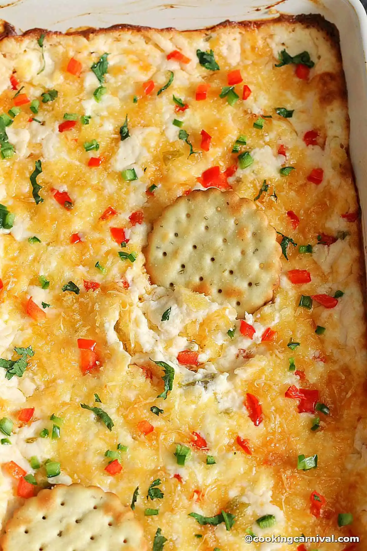 scooping jalapeno dip with crackers.