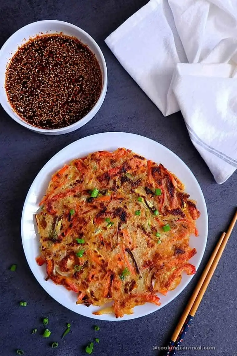 Korean vegetable pancake in white plate with dipping sauce