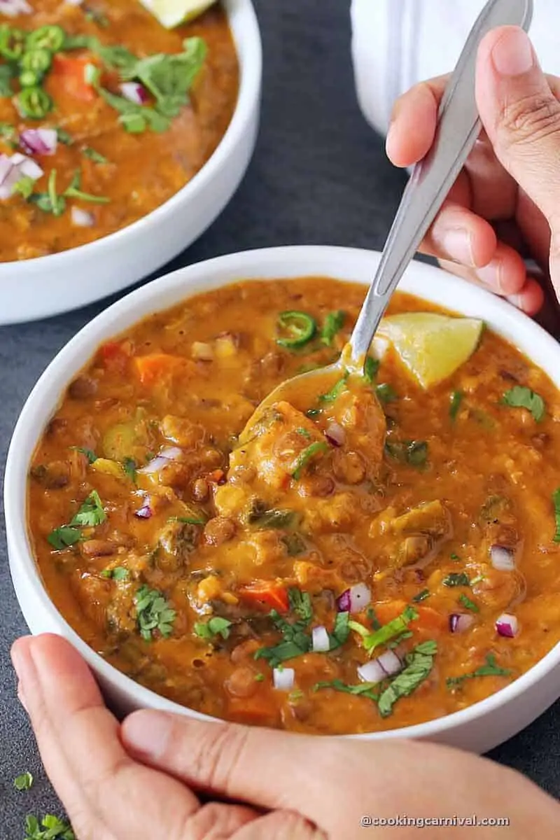 taking spoon full of Moroccan lentil soup from bowl