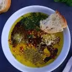 Olive oil with herbs for bread in a white bowl