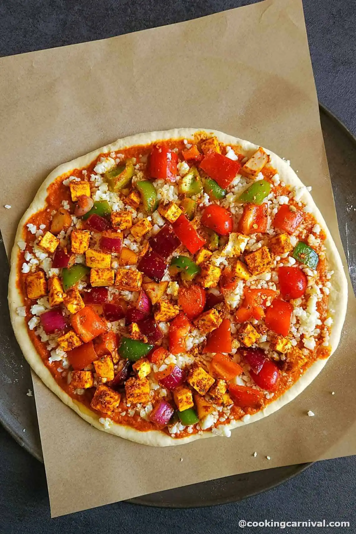 Paneer pizza is ready to go into the oven.