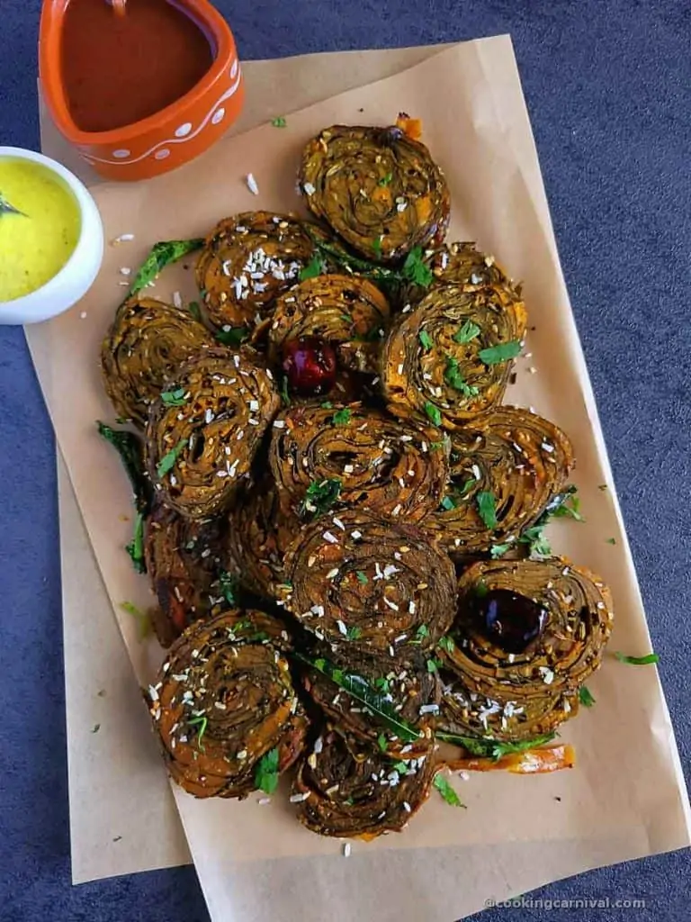 Patra on a gray table with cilantro and sweet chutney