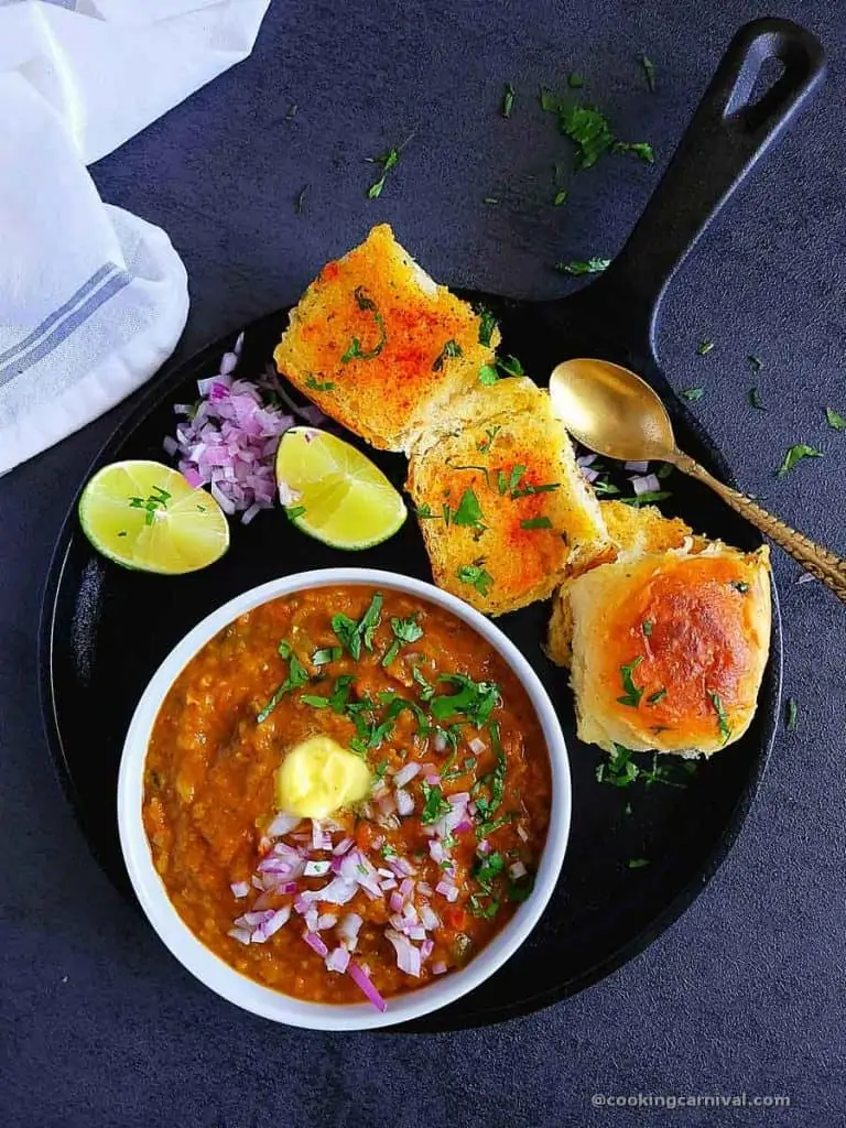 Bhaji served with pav, onion, cilantro, lemon