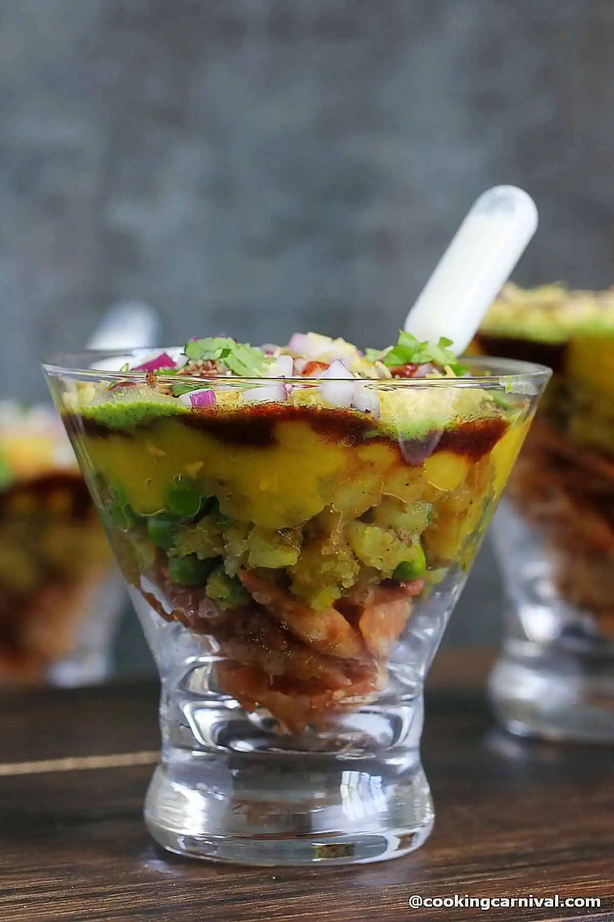 Showing the layers of samosa chaat served in cup.