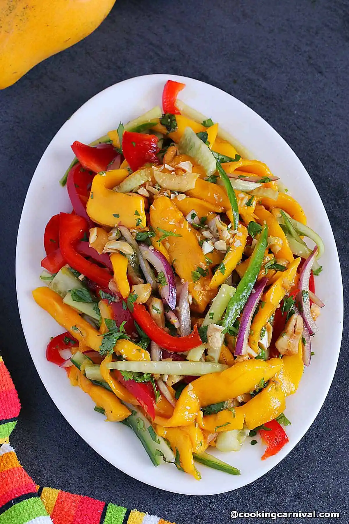 Thai mango salad served in white ovel plate.