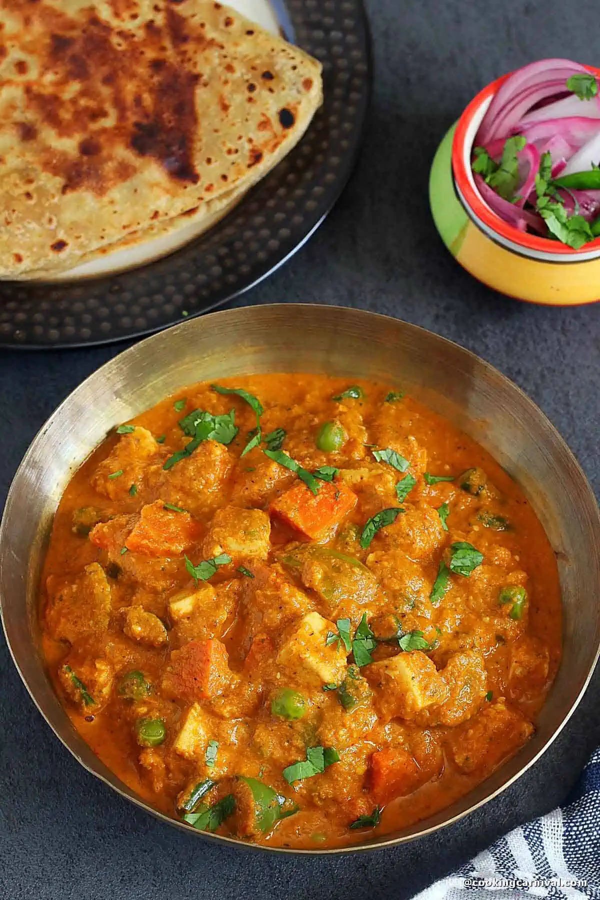 mixed veg maratha with paneer served with paratha and onion.