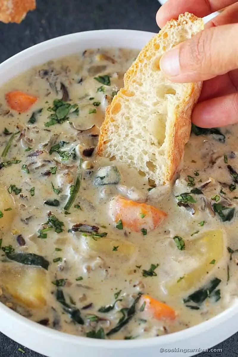 Dunking crusty bread in Vegetable Wild Rice Soup